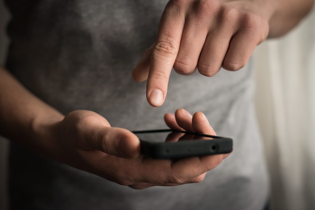 A man touching a smartphone